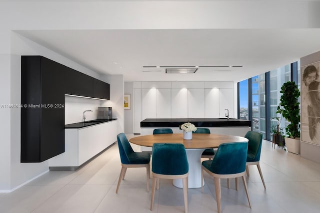 dining room with light tile flooring, expansive windows, and sink