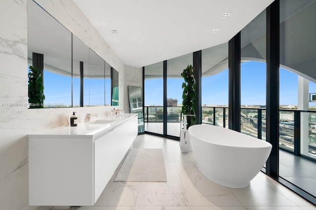 bathroom featuring tile flooring, sink, a washtub, and floor to ceiling windows