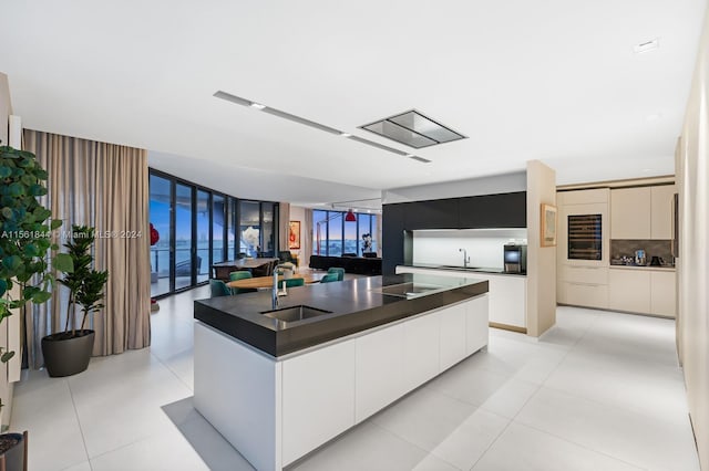 kitchen featuring sink, a kitchen island, and light tile floors