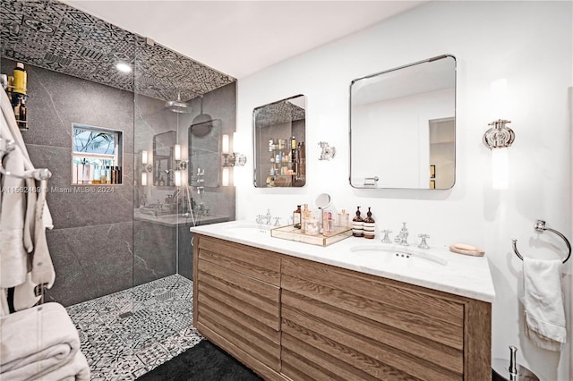 bathroom with a tile shower and vanity