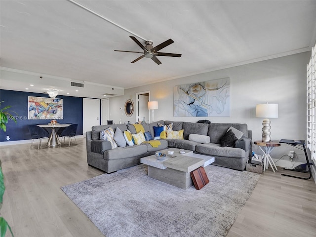 living room featuring ceiling fan, crown molding, and light hardwood / wood-style flooring