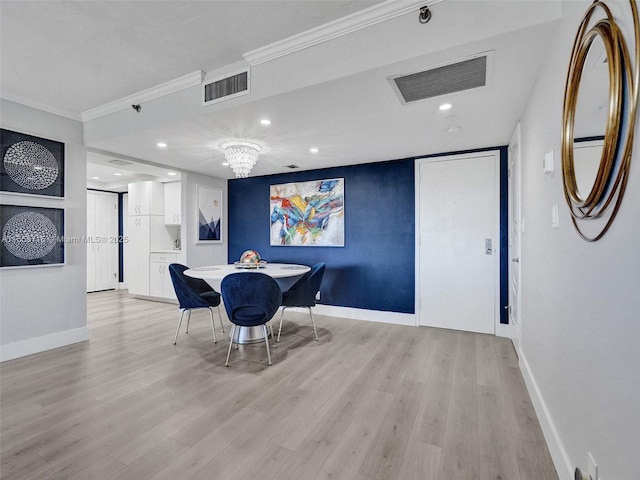 dining area featuring a chandelier, light hardwood / wood-style flooring, and ornamental molding