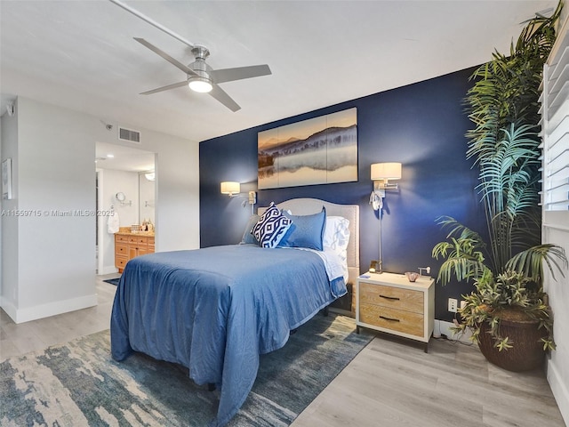 bedroom featuring ensuite bathroom, light hardwood / wood-style flooring, and ceiling fan