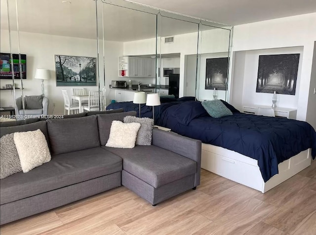 bedroom with a closet and light hardwood / wood-style flooring