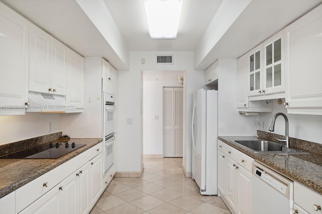 kitchen featuring light tile patterned floors, custom exhaust hood, white cabinets, and white appliances