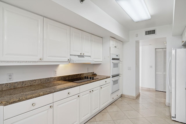 kitchen with light tile patterned floors, custom exhaust hood, white cabinets, and white appliances