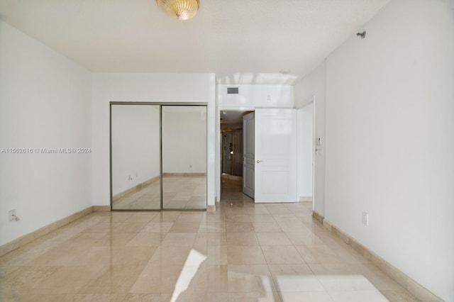 unfurnished bedroom with a closet and light tile patterned floors