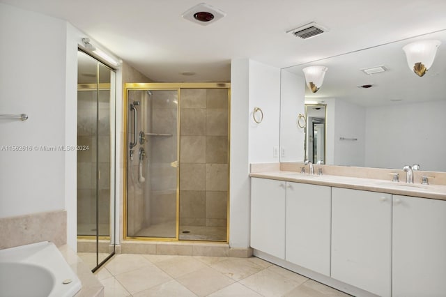 bathroom with tile patterned floors, double vanity, and separate shower and tub