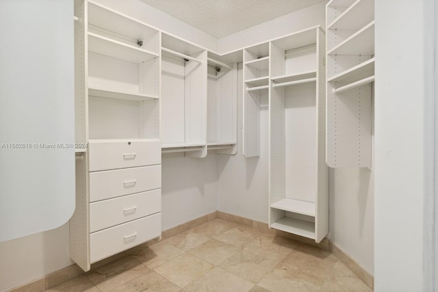 walk in closet with light tile patterned floors