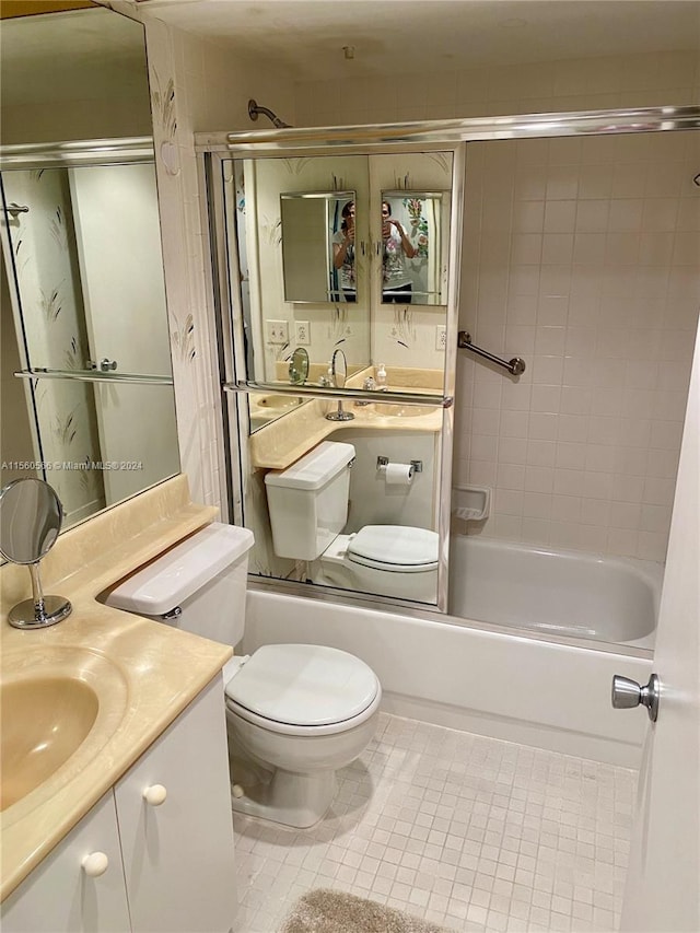 full bathroom featuring tile patterned flooring, toilet, vanity, and tiled shower / bath