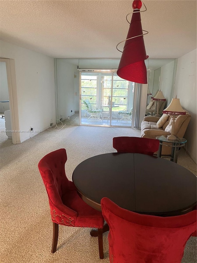 carpeted dining room featuring a textured ceiling