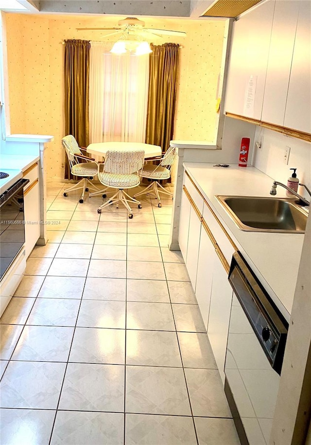 kitchen featuring white cabinetry, sink, white dishwasher, and light tile patterned flooring