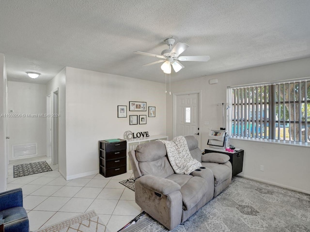 tiled living room with a textured ceiling and ceiling fan