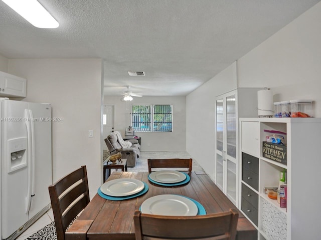 dining space featuring a textured ceiling and ceiling fan