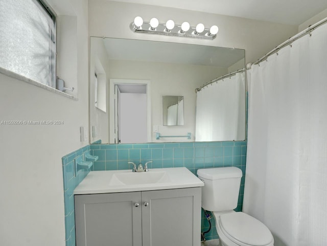 bathroom with tasteful backsplash, oversized vanity, toilet, and tile walls