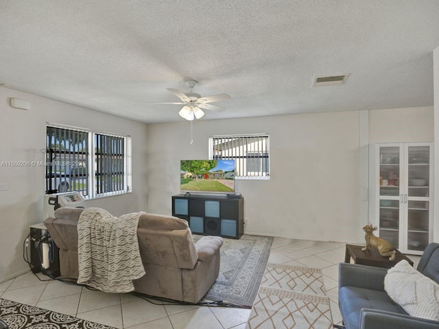 living room featuring plenty of natural light, ceiling fan, and light tile floors