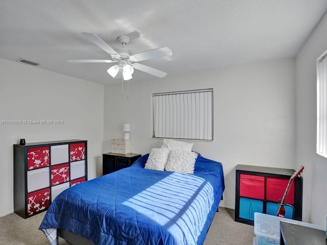 carpeted bedroom featuring a textured ceiling and ceiling fan