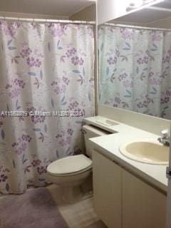 bathroom featuring vanity, curtained shower, and toilet