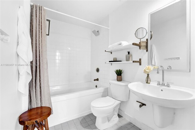 bathroom with toilet, shower / tub combo with curtain, and tile patterned flooring