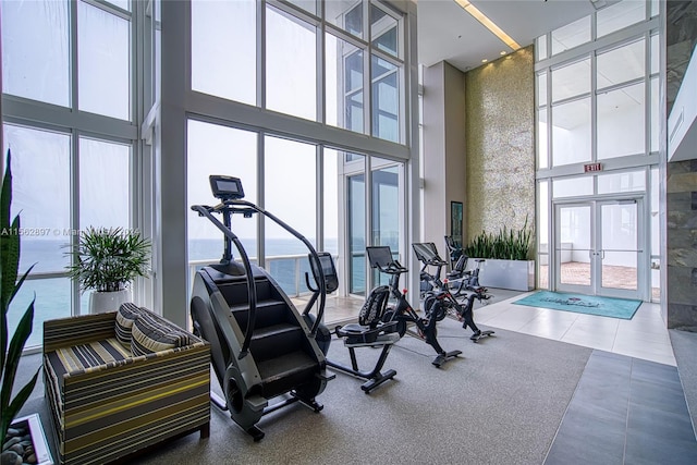 workout area featuring french doors, tile flooring, and a high ceiling