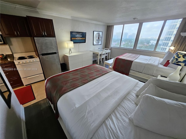 bedroom featuring stainless steel fridge, ornamental molding, and light wood-type flooring