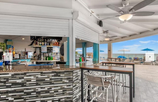 view of patio featuring exterior bar and ceiling fan