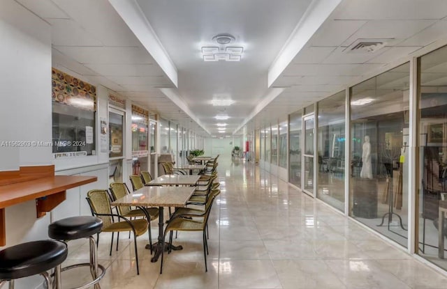 hall featuring a textured ceiling, light tile patterned floors, elevator, and ornamental molding