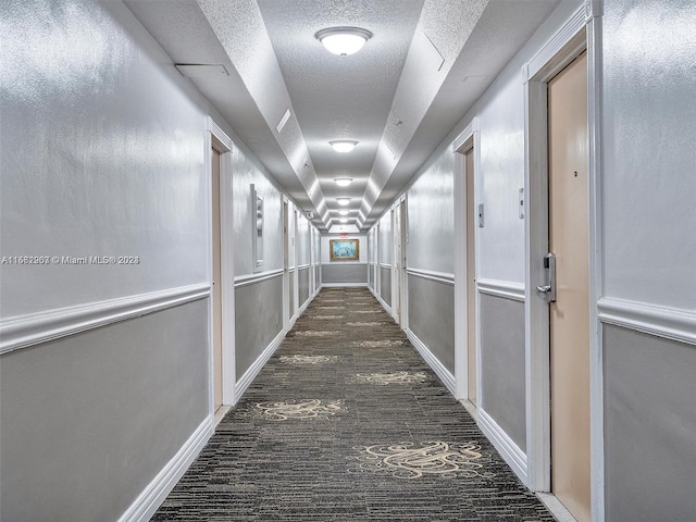 hallway featuring a textured ceiling and dark hardwood / wood-style flooring