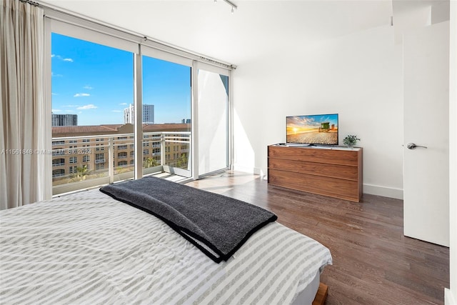 bedroom featuring expansive windows and dark wood-type flooring