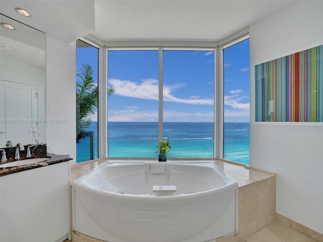 bathroom with a water view, sink, and a bath to relax in