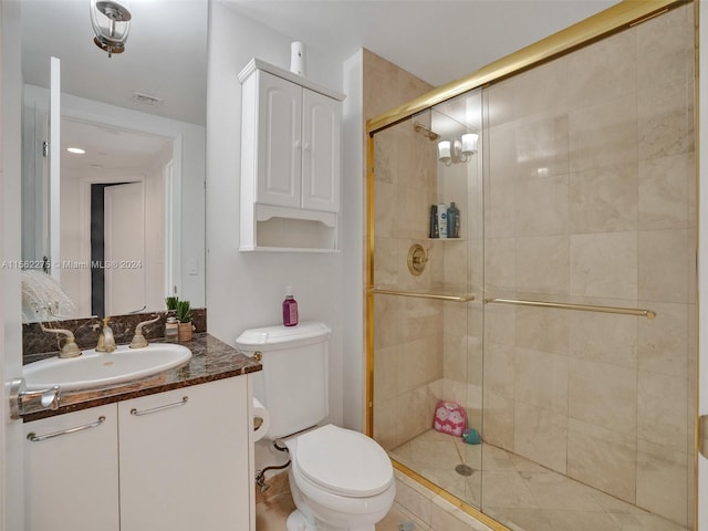 bathroom featuring a shower with shower door, oversized vanity, and toilet