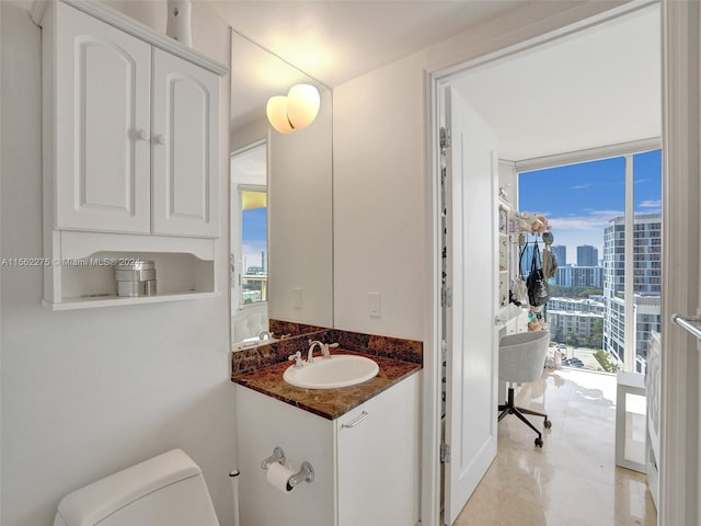 bathroom featuring oversized vanity, toilet, and tile floors