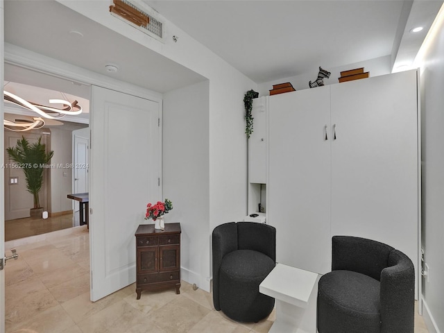 living area featuring light tile flooring and a chandelier