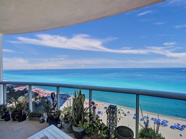 balcony with a water view and a view of the beach