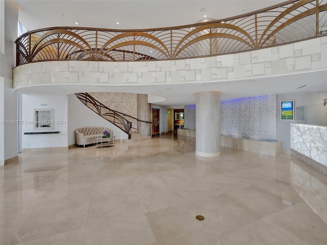 interior space with light tile flooring and a towering ceiling