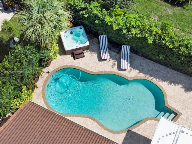 view of swimming pool with a hot tub and a patio area