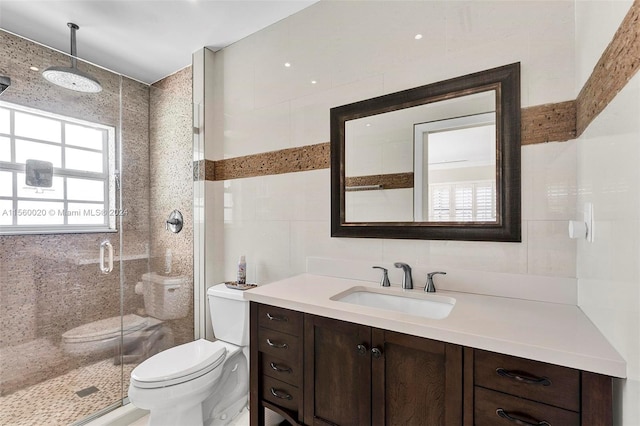 bathroom with a wealth of natural light, a shower with door, toilet, and tile walls