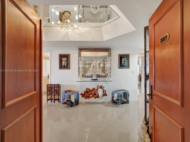 tiled foyer entrance with a notable chandelier