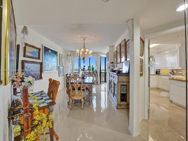 dining room featuring an inviting chandelier, a textured ceiling, and light tile floors