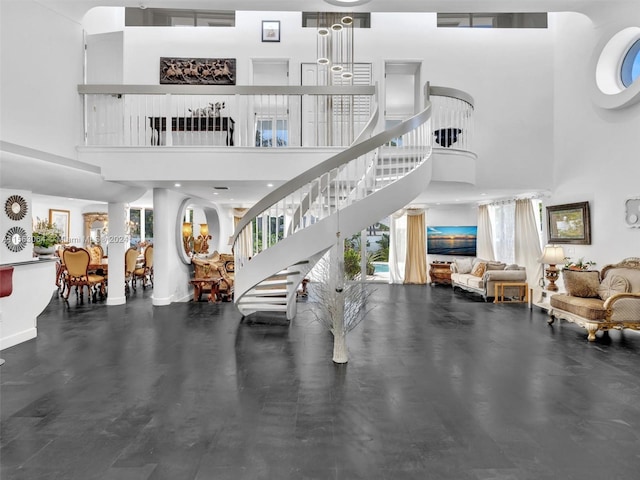 interior space with a notable chandelier, a healthy amount of sunlight, and a towering ceiling