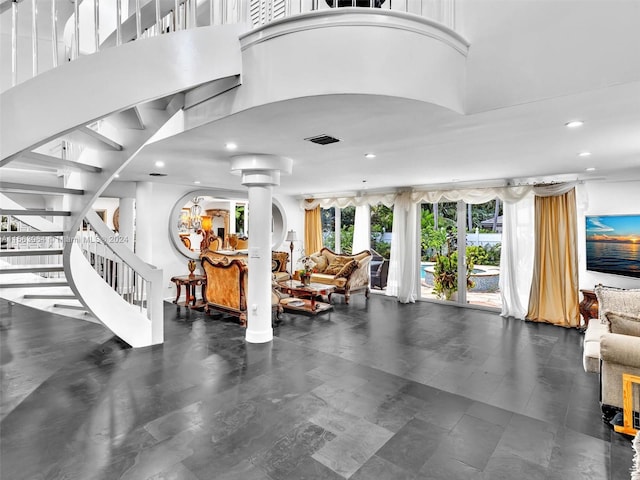 gym with dark tile flooring, a high ceiling, and ornate columns