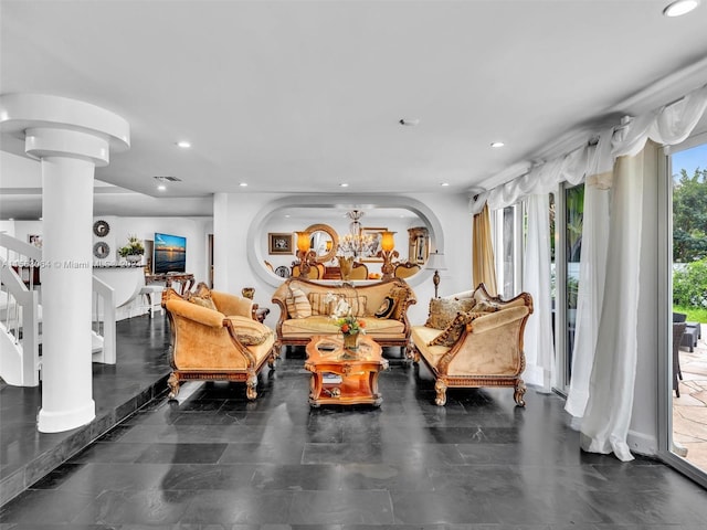 tiled living room featuring a chandelier and decorative columns