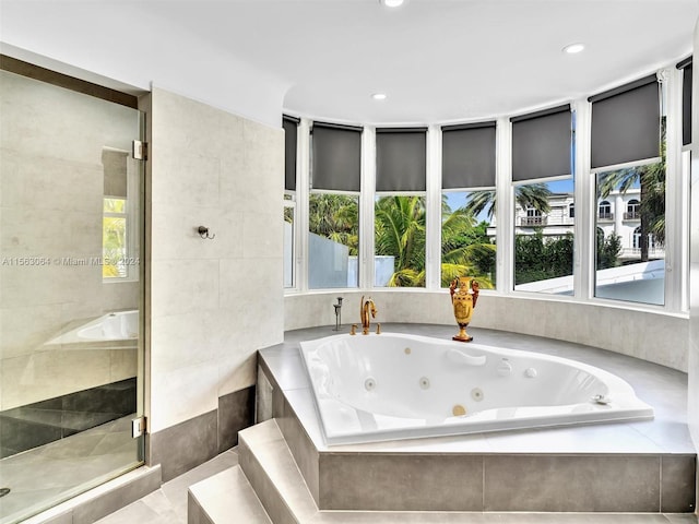 bathroom with tile flooring, plus walk in shower, and a healthy amount of sunlight