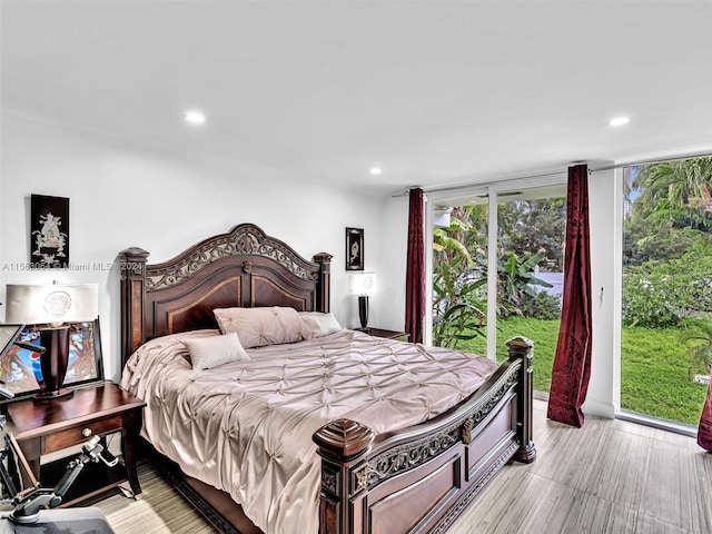 bedroom featuring multiple windows, light hardwood / wood-style flooring, and access to outside