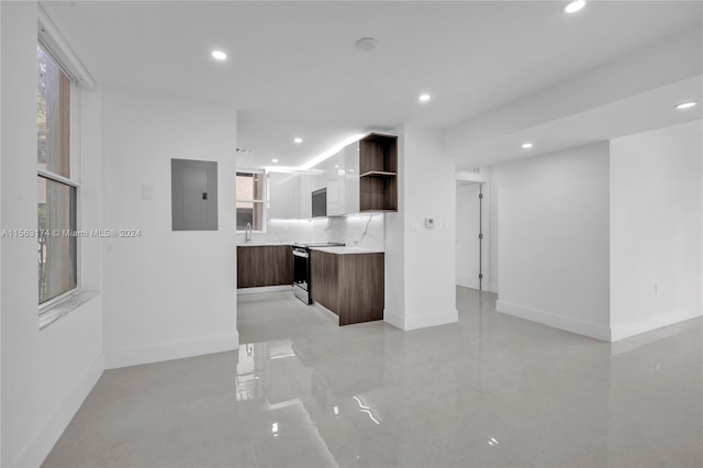 kitchen featuring dark brown cabinetry, stove, tasteful backsplash, and sink