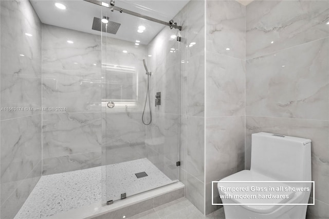 bathroom featuring tiled shower, tile floors, and tile walls