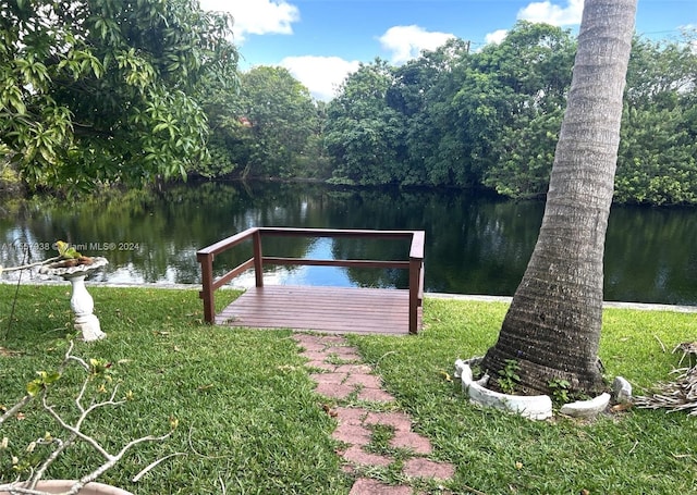 dock area with a yard and a water view