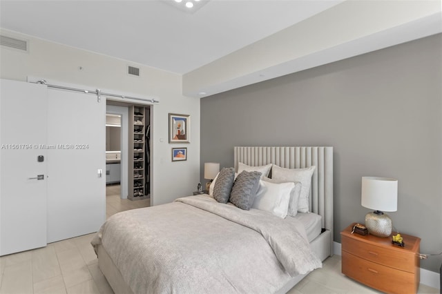 bedroom with a barn door, a walk in closet, and a closet