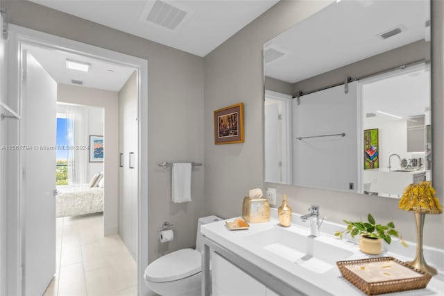 bathroom with toilet, vanity, and tile patterned floors