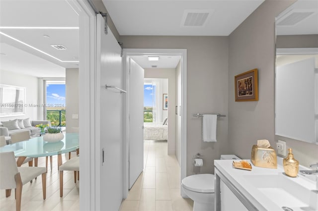 bathroom with tile patterned flooring, vanity, and toilet